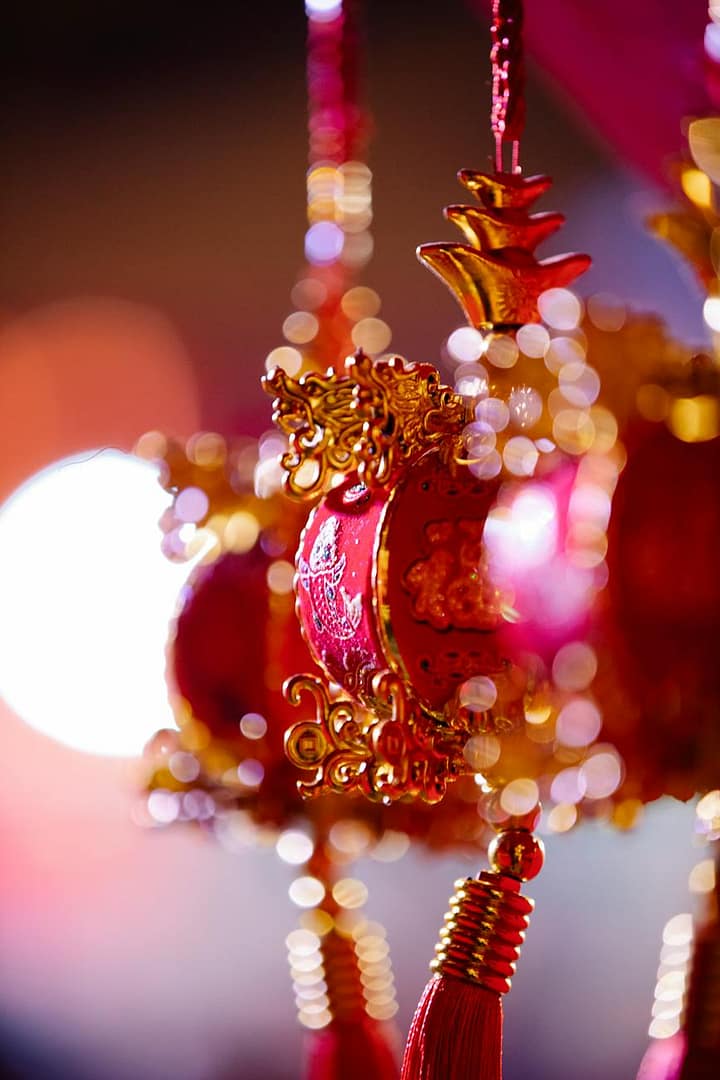 traditional ornamental red and golden baubles hanging on street in evening